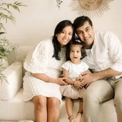 A classic family portrait on the studio couch. The neutral tones and simple setting really let the family's connection shine.
