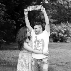 A fun and creative way to announce a pregnancy. This couple joyfully holds up their sonogram pictures during their outdoor maternity shoot in a park.