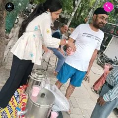 One of our volunteers serving a refreshing drink to a passerby. Every glass is served with a smile and 100% love.
