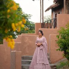The bride posing on the steps of the rustic venue. This shot showcases her complete outfit against the unique architecture of the resort.