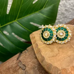A pair of classic round studs, elevated with rich green meenakari work and a halo of sparkling kundan stones.