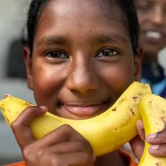 A smile powered by good nutrition. A young player enjoys a post-training banana, a simple and effective way to replenish energy.