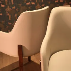 A detail shot focusing on the elegant curves of the upholstered armchair. This view highlights the seamless finish and the quality of the material, showcasing the craftsmanship that goes into every piece I create.