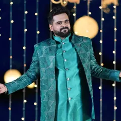 Client Rishabh owning the night at his sangeet. He is wearing a custom teal Indo-Western jacket with a geometric pattern, designed to make a statement.