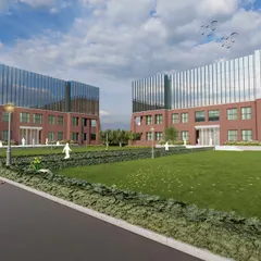 A wide view of the campus lawn, illustrating how the architectural design frames the landscape. The open green space acts as the heart of the campus, connecting the different academic blocks.