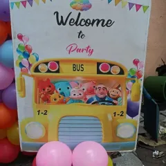 A Cocomelon-themed welcome sign for a birthday party. This fun prop, featuring characters on a yellow bus, is a great way to greet young guests.
