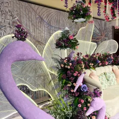 Sculptural swan props and hanging birdcages filled with flowers add a whimsical touch to our illuminated garden theme.