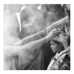 A powerful black and white photo of a sacred wedding ritual. The smoke and focused expressions create a dramatic and spiritual atmosphere.
