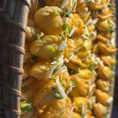 This is my take on the traditional Maharashtrian karanji. These sweet dumplings are beautifully arranged in a rustic wicker basket and garnished with slivered almonds, ready to be served.