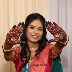 A happy bride showcasing the beautiful, dark stain on both her hands, a result of natural henna and good aftercare.