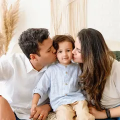 A sweet family moment with parents kissing their son's cheeks. I encourage these affectionate interactions to capture genuine love during our studio sessions.
