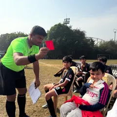 Even on the bench, there's drama and fun. A lighthearted moment with the referee and one of our youngest players.