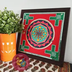 This vibrant Sriyantram painting, framed and styled in a home setting. The geometric precision and bright colors are designed to bring positive energy and focus, making it a perfect piece for a meditation space or living room.