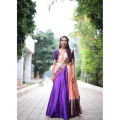This is a complete South Indian half saree, or langa voni, that I designed. The rich purple silk skirt contrasts beautifully with the peach and gold dupatta, creating a stunning outfit perfect for a wedding or pre-wedding celebration.