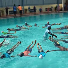 An instructor adjusts a participant's form during our Aqua Yoga session. We provide hands-on guidance to ensure everyone feels comfortable and gets the full benefit of the water-based practice.