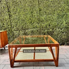 A frontal view of the glass and cane coffee table, highlighting its clean, geometric lines.
