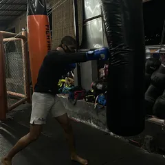 A fighter demonstrates a powerful right cross on the heavy bag. This photo captures the focus and technique required to generate knockout power in boxing.