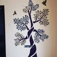 A stylized two-tone tree mural adds an artistic and modern touch to this wall. This type of design is versatile and works well in entryways, living rooms, or bedrooms.