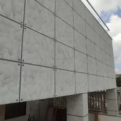 This image showcases a modern exterior finish with a panelled texture effect. This type of decorative work can give a unique and sophisticated look to the outside of your home or commercial building.