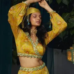 A beautiful, expressive pose from a fashion lookbook. The makeup is warm and sun-kissed, with a focus on glowing skin and softly defined eyes, perfectly suiting the bohemian-inspired yellow outfit.