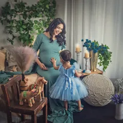 A sweet interaction between a mother-to-be and her daughter. The little girl reaches out to touch her mommy's belly, curious about the new life inside.