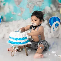 A full view of the cake smash in progress. We love capturing the messy hands and face, a classic part of any first birthday celebration.