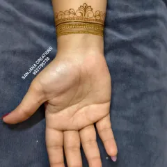 A classic bridal wrist cuff. This design features a traditional crown-like border with intricate line and dot work, a timeless choice for any bride.