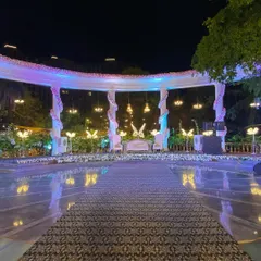 This elegant reception stage, set by a poolside, features a grand white structure with hanging chandeliers and glowing butterfly motifs. We designed it to be a magical focal point for the couple's special evening.