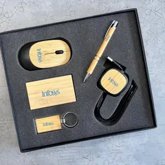 For a more sustainable option, I offer eco-friendly tech kits. This set for Infosys features a wireless mouse, retractable USB cable, card holder, pen, and keychain, all made with bamboo and customized with their logo.