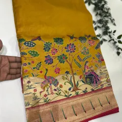A close-up of the stunning Meenakari pallu on our Dola Paithani saree in a rich mustard yellow. The intricate weaving tells a story of its own.
