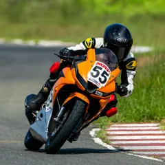 This front-quarter view highlights the rider's head and eye position, looking through the turn towards the exit. This is a key technique I emphasize for smooth and fast cornering on the racetrack.