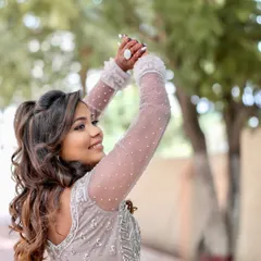 Reception ready in a stunning silver gown. The makeup is soft yet glamorous, with shimmering eyes and beautiful curls, creating a look that is perfect for celebrating the night away.