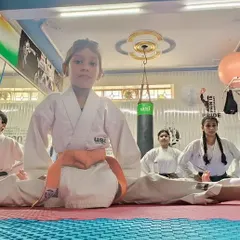 A young student demonstrates incredible flexibility by holding a perfect center split, a skill developed through consistent practice and stretching routines at our academy.