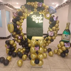 For a bold and glamorous bridal shower, I used a black and gold color scheme. This balloon ring backdrop is accented with a "Bride to be" neon sign and large foil balloons of a diamond ring and a champagne bottle for a fun, celebratory theme.