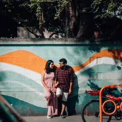 A couple holds hands in front of a colorful mural, blending their story with the art of the street. Urban environments provide endless opportunities for creative and vibrant couple portraits.