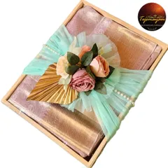 A premium gift hamper featuring a beautiful silk saree, elegantly packed in a wooden box with a floral and tulle arrangement.