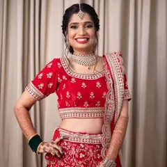 A radiant bride ready for her Sangeet night. She is wearing a beautiful red lehenga, and I created a glowing makeup look with a braided hairstyle adorned with fresh flowers.
