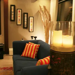 Creating a cosy corner is all about thoughtful home styling. Here, I used warm lighting from the large candle holder, contrasting striped cushions on the deep blue sofa, and curated wall art to make this little nook feel intimate and personal. It shows how even small changes can completely transform the mood of a space.