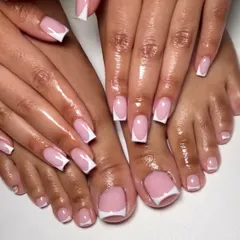 The ultimate clean and classic look. This photo showcases a matching set of flawless French manicures on both hands and feet, featuring crisp white tips and a sheer pink base.