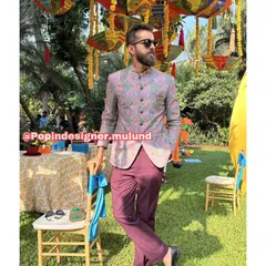 A solo shot of the client in the printed Jodhpuri jacket. The vibrant colors and patterns are perfect for a festive, celebratory atmosphere.
