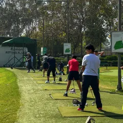 The bays are packed with golfers working on their game. This view from behind the line shows a typical busy day at the camp, with everyone focused on their practice.