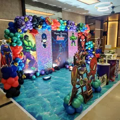 A wide view of the superhero party hall, showing the impressive scale of the decorations, including a custom-printed floor that looks like water, making the heroes' arrival even more dramatic.