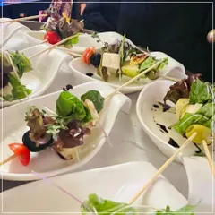 A fresh and vibrant salad served on a skewer. This appetizer features cherry tomatoes, olives, paneer, and mixed greens drizzled with a light vinaigrette, offering a crisp and healthy bite-sized option for any event.