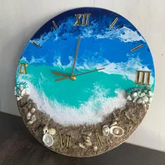 This ocean clock features vibrant turquoise water and a detailed beach with tiny shells and pearls.