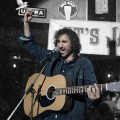 A powerful shot of our guitarist and vocalist, Jas, leading the crowd in a sing-along. His passion for music shines through in every performance.