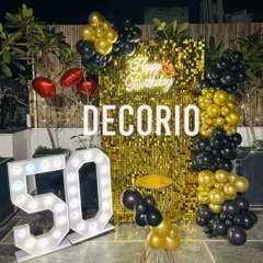 A spectacular 50th birthday party on a terrace, designed for a memorable night-time celebration. This setup features a brilliant gold sequin backdrop, a custom neon sign, large light-up '50' marquee numbers, and a dramatic black and gold balloon arrangement.