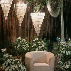 A vision in white. For this elegant cocktail dinner, we designed a stunning tablescape with a lush runner of white flowers and greenery, set under a transparent roof filled with fairy lights for a magical, starlit dining experience.