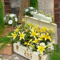 Thinking outside the box for floral displays. Here, a vintage white suitcase overflows with bright yellow lilies and baby's breath, creating a unique and memorable decor piece for the citrus themed shower.