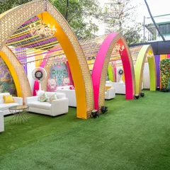 This outdoor lounge area was designed for a vibrant Garba night. We used a series of colorful arches with intricate gold lattice work and ribbon canopies to create semi-private seating zones, combining modern comfort with a festive, traditional atmosphere.