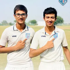 Pointing to the badge with pride. Laksh Narang and Saiansh Vohra represent the quality and spirit of the Delhi Cricket Hub. Their record-breaking performances make all the hard work worth it.